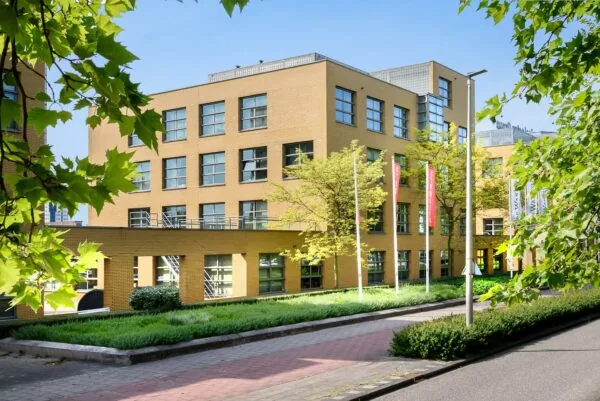 Modern kantoorgebouw aan de Rivium 2e Straat in Capelle aan den IJssel, omgeven door groen en vlaggenmasten.